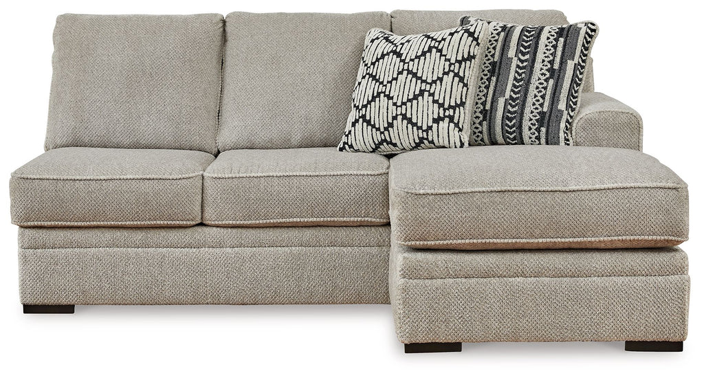 Sofa chaise sectional with light gray upholstery, wide chaise ottoman and patterned cushion