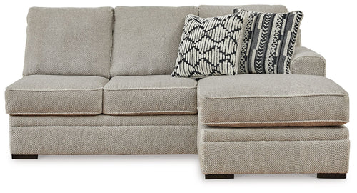 Sofa chaise sectional with light gray upholstery, wide chaise ottoman and patterned cushion