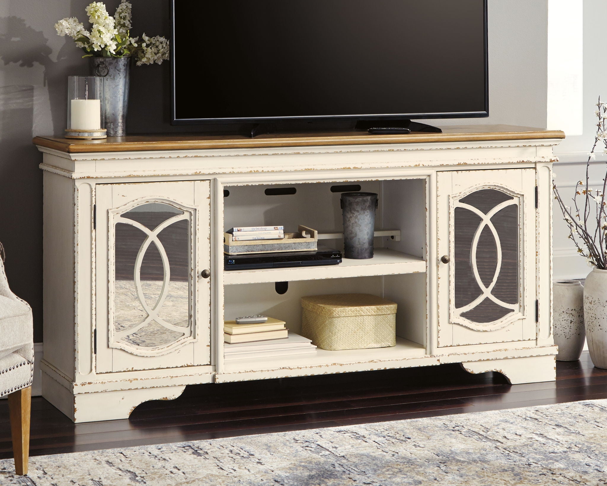 Chipped white TV stand with two cabinet doors, open shelves, and TV on top