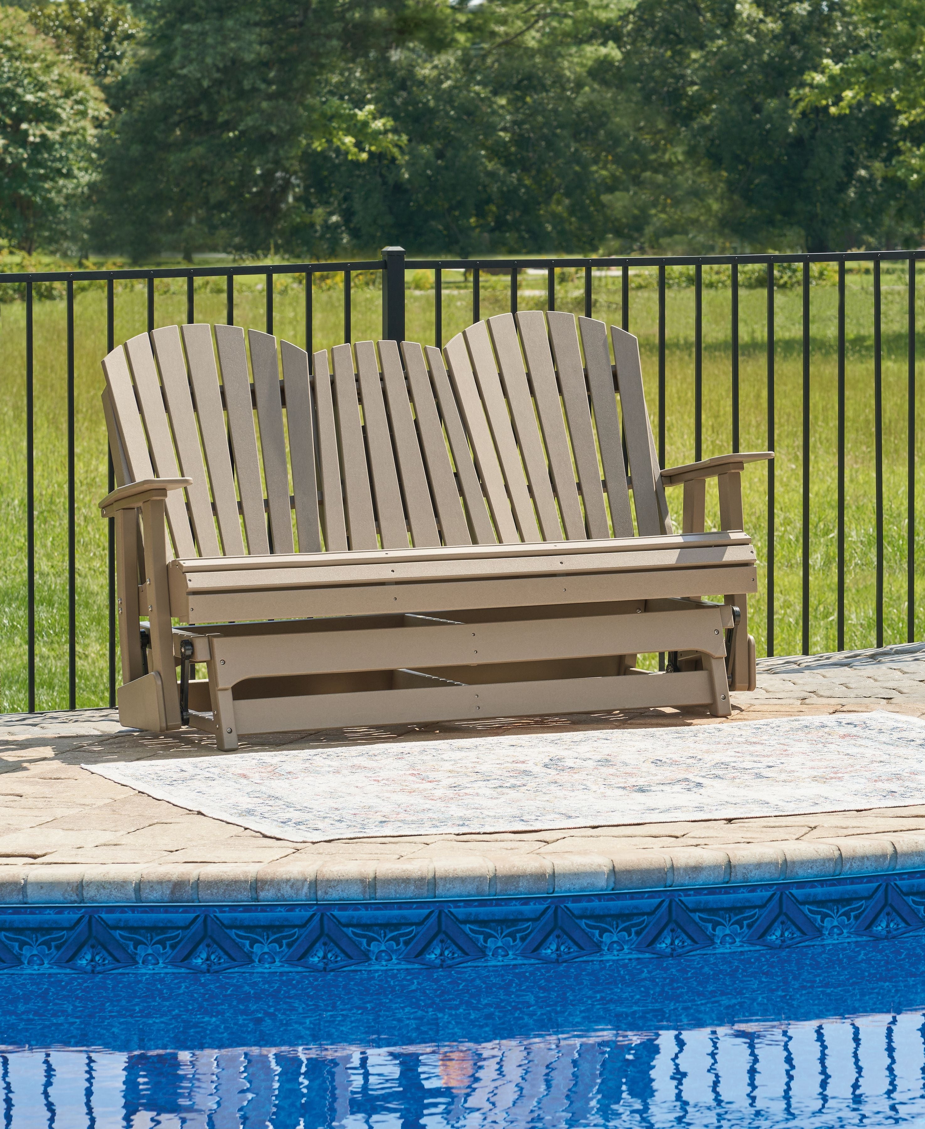Outdoor glider loveseat with two slat seats, pale frame, and curved slat backs