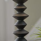 Black stacked geometric lamp base detail with brushed texture