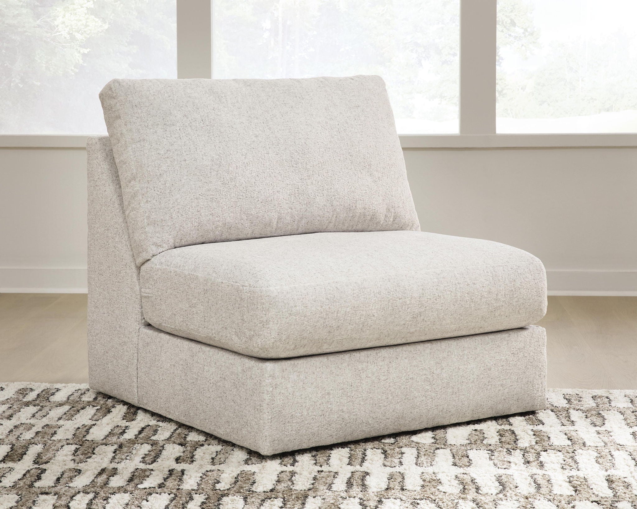 Light beige armless accent chair with thick seat and rounded back