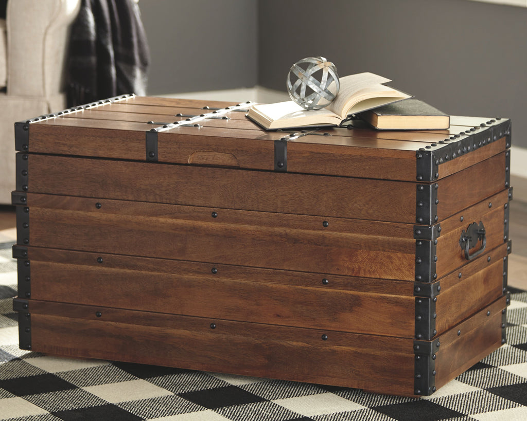 Brown wooden storage trunk with hinged lid, black metal corner studs and latch straps.