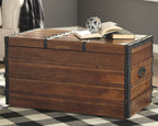Brown wooden storage trunk with hinged lid, black metal corner studs and latch straps.