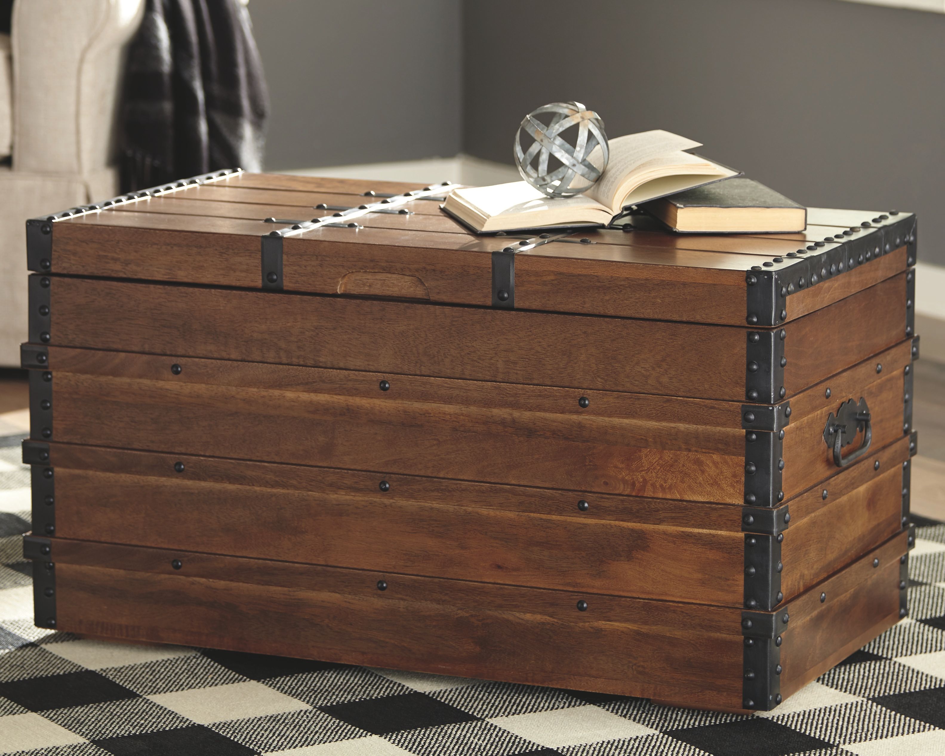 Brown wooden storage trunk with hinged lid, black metal corner studs and latch straps.