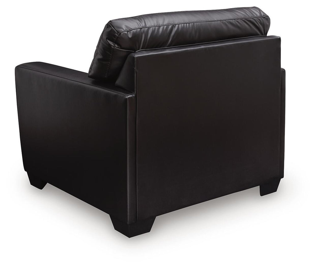 Midnight black upholstered armchair side view with curved padded armrests