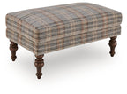 Multi plaid upholstered accent ottoman with tufted top and dark turned wooden legs