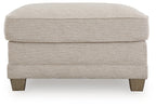 Opal upholstered ottoman with cushioned seat, stitched sides, and wooden legs