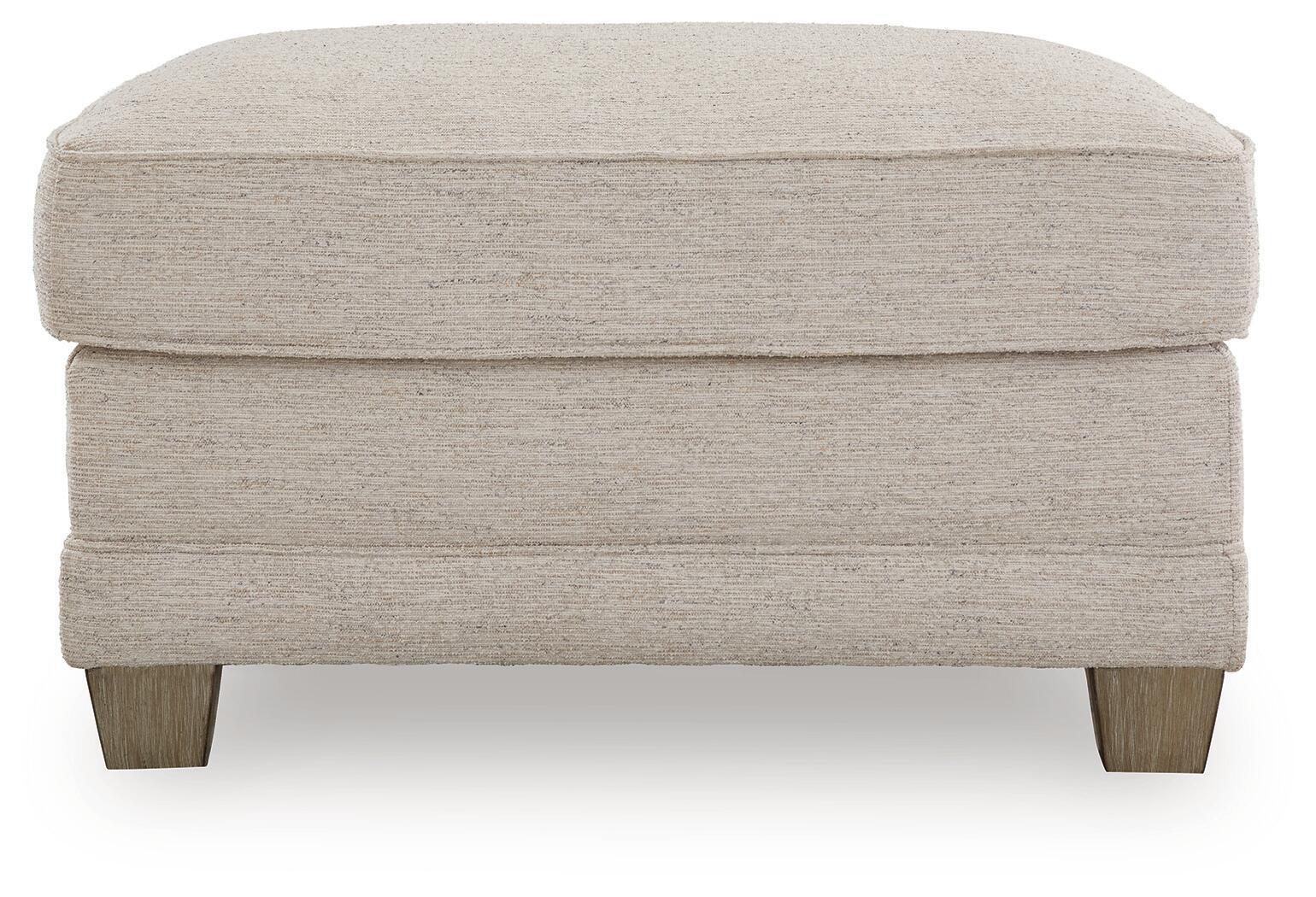 Opal upholstered ottoman with cushioned seat, stitched sides, and wooden legs