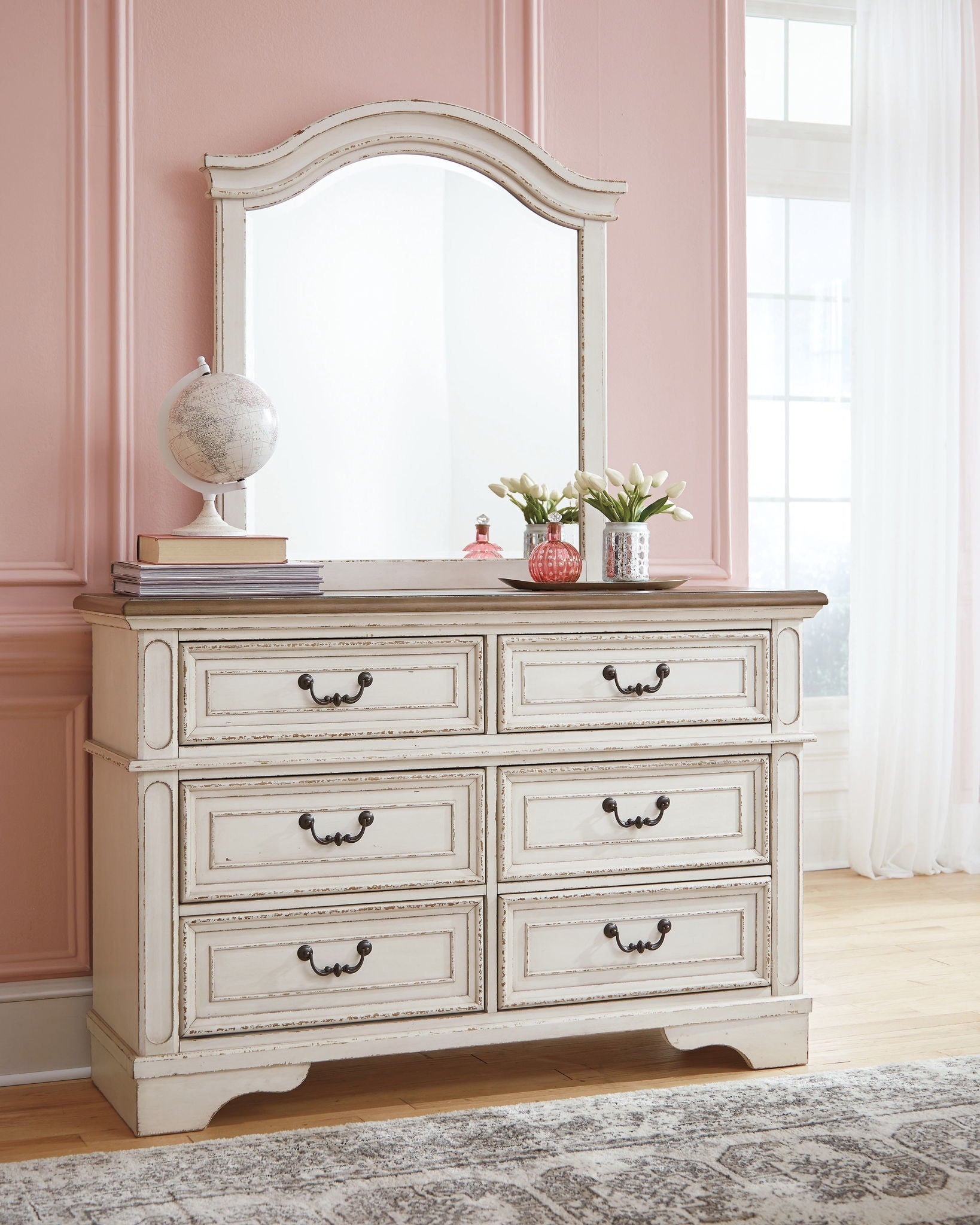 White dresser with mirror and six drawers, decorative frame and curved skirt base.