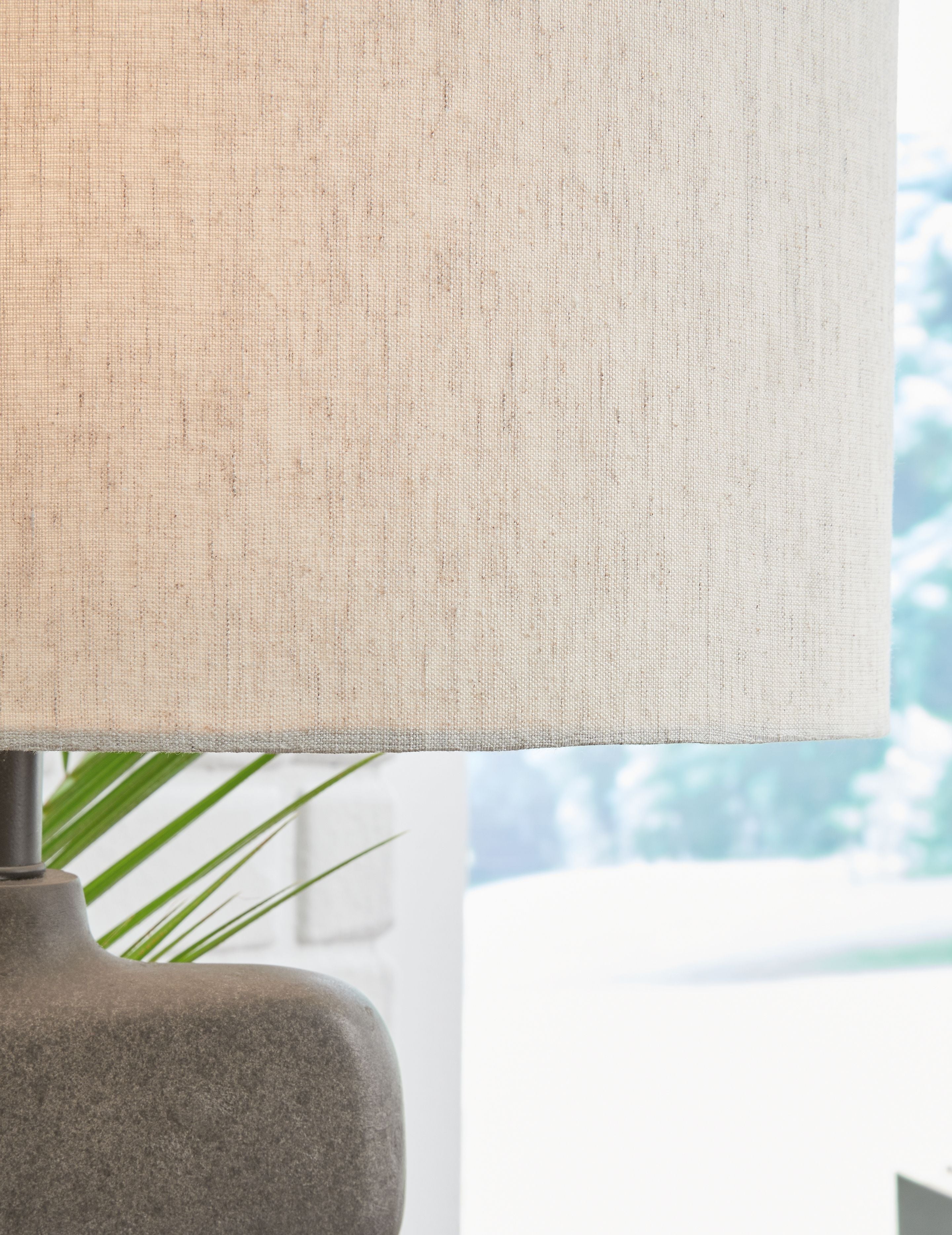 Danacy paper table lamp close-up: textured beige shade over dark gray sculpted base