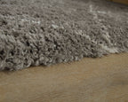 Dark gray shag area rug edge close-up with dense, textured pile