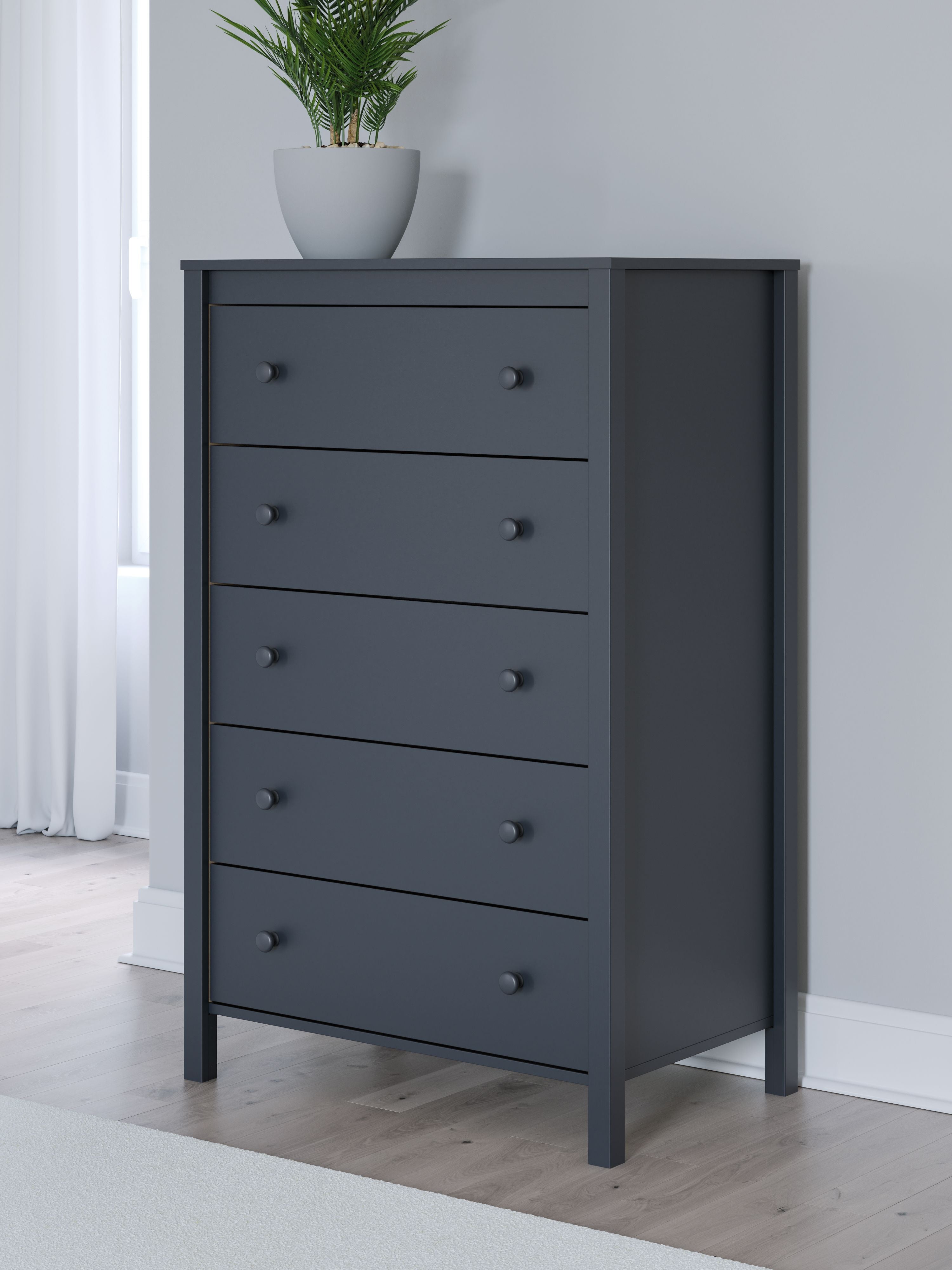 Navy blue five-drawer chest with round knobs, side panel visible