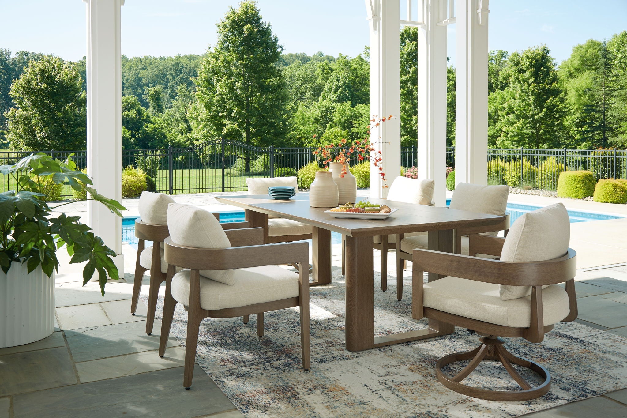 Outdoor dining set with dark brown table and beige-cushioned armchairs on patio
