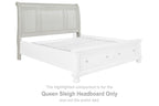 Antique white queen sleigh headboard with arched silhouette and vertical paneling, on bed