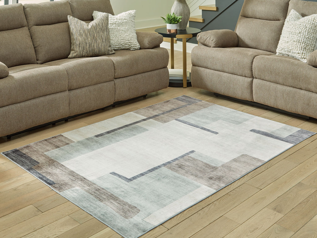 Beige and gray abstract washable rug laid out under living room seating