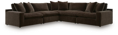 Dark brown L-shaped sectional sofa with tufted-look seat cushions and layered back pillows.
