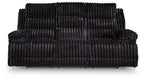 Black corduroy reclining sofa with padded arms and segmented seat back cushions