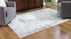 Light blue washable rug with distressed abstract pattern on low pile