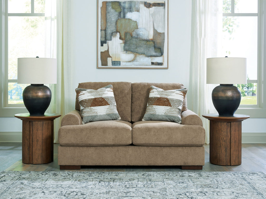 Beige loveseat sofa with two seat cushions and patterned accent pillows, square arms