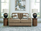 Beige loveseat sofa with two seat cushions and patterned accent pillows, square arms