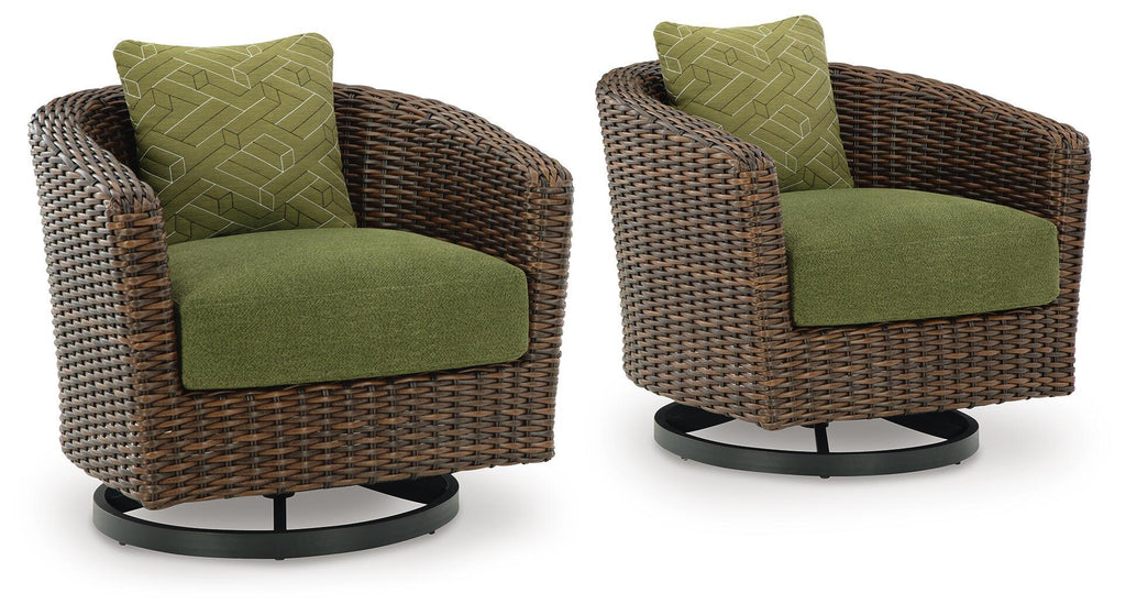 Brown woven wicker swivel lounge chair with green seat cushion and patterned back pillow