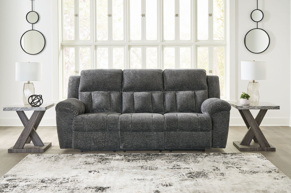 Graphite gray reclining sofa with tufted cushions, rounded arms, and centered seat back