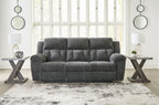 Graphite gray reclining sofa with tufted cushions, rounded arms, and centered seat back
