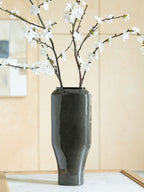 Dark speckled ceramic vase with glossy finish and flared open top