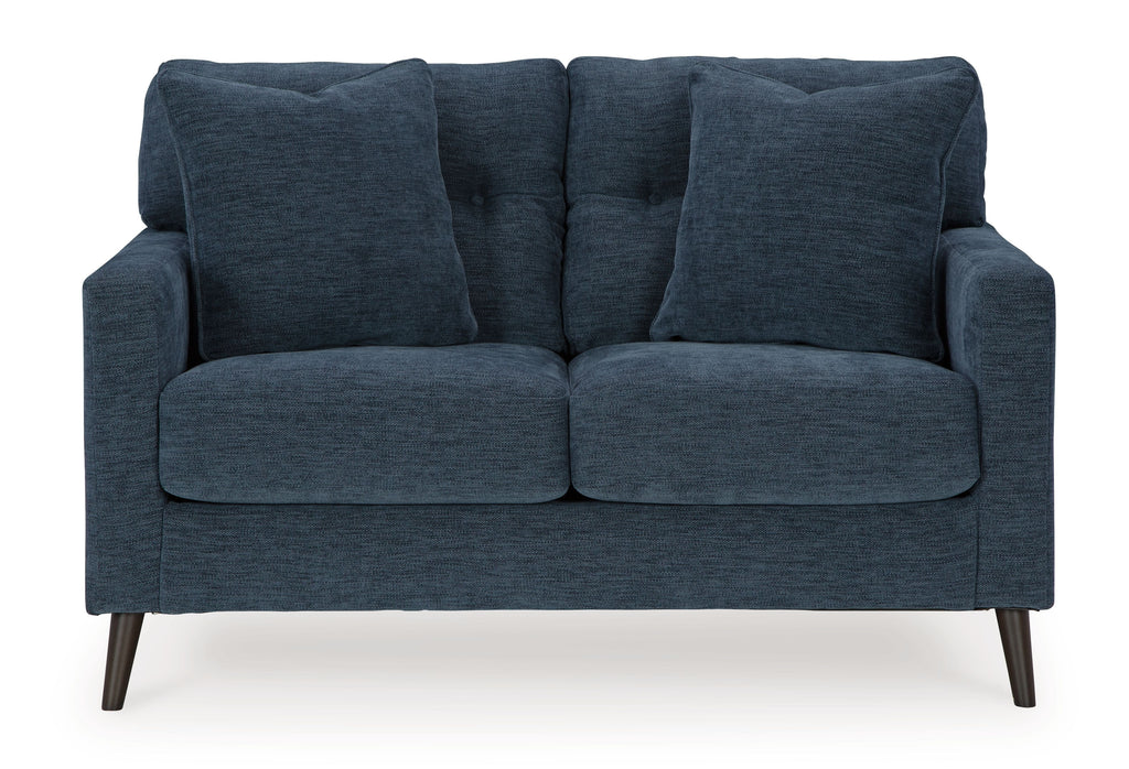 Blue loveseat with tufted back and two padded seat cushions with rolled arms.