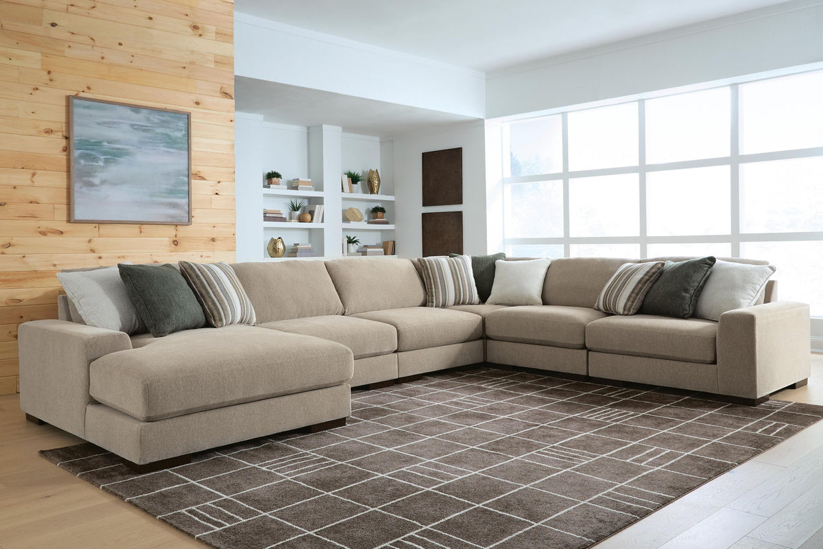 Light brown sectional sofa with chaise, layered pillows, and solid seat cushions