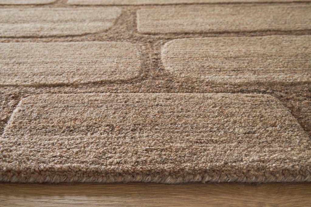 Brown and beige textured rug pile with stitched edge binding
