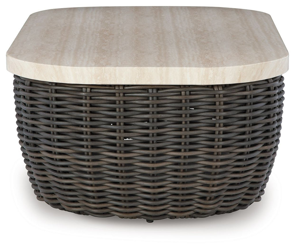 Beige tabletop on dark brown wicker cocktail table with rounded corners