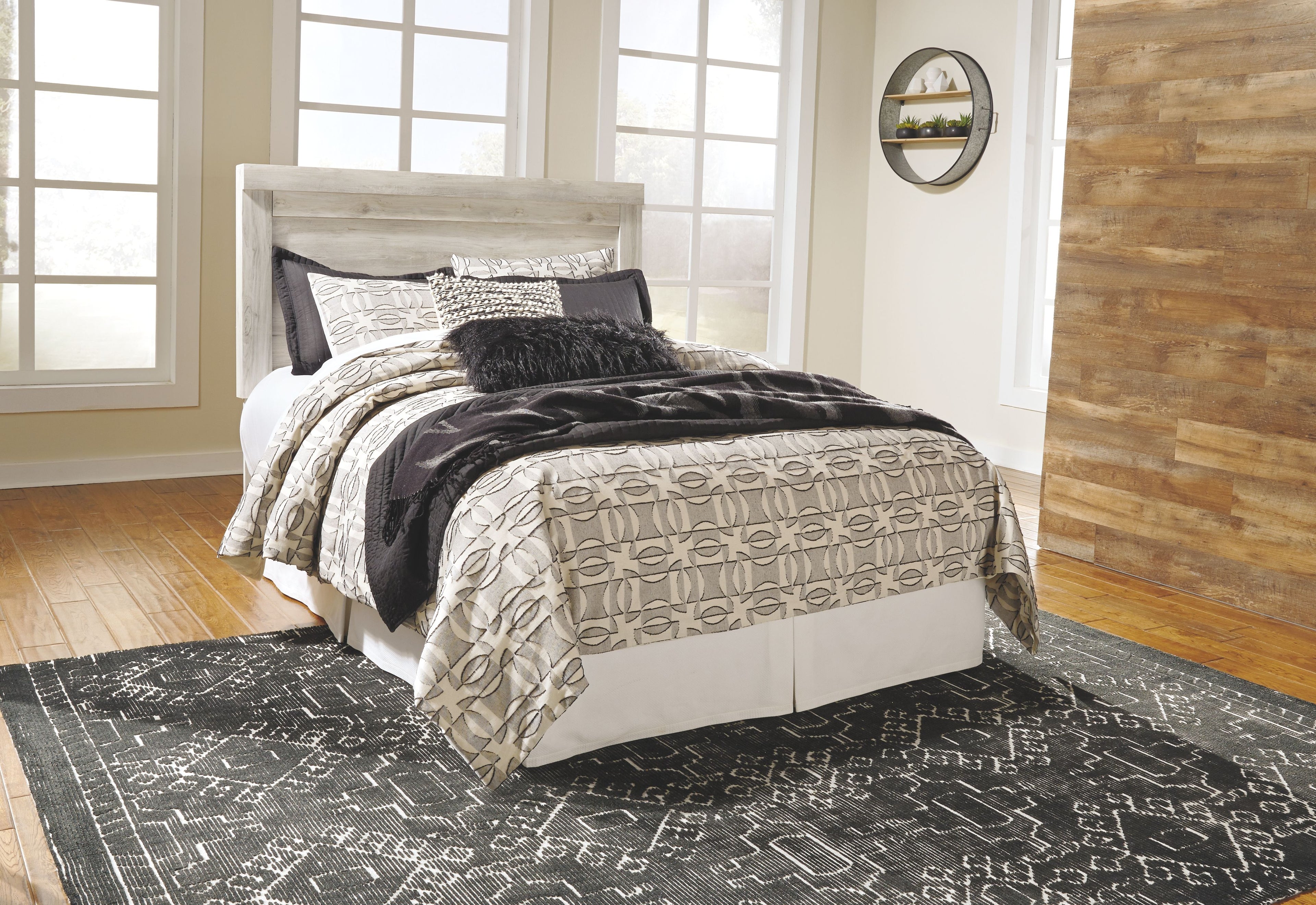 Bellaby beige upholstered panel headboard with bed frame and patterned bedding
