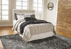Beige panel headboard with bolt-on metal bed frame and patterned bedding