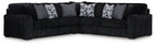 Black corded sectional sofa with chaise and gray patterned throw pillows
