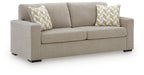 Light gray upholstered sofa with two back pillows in light geometric fabric
