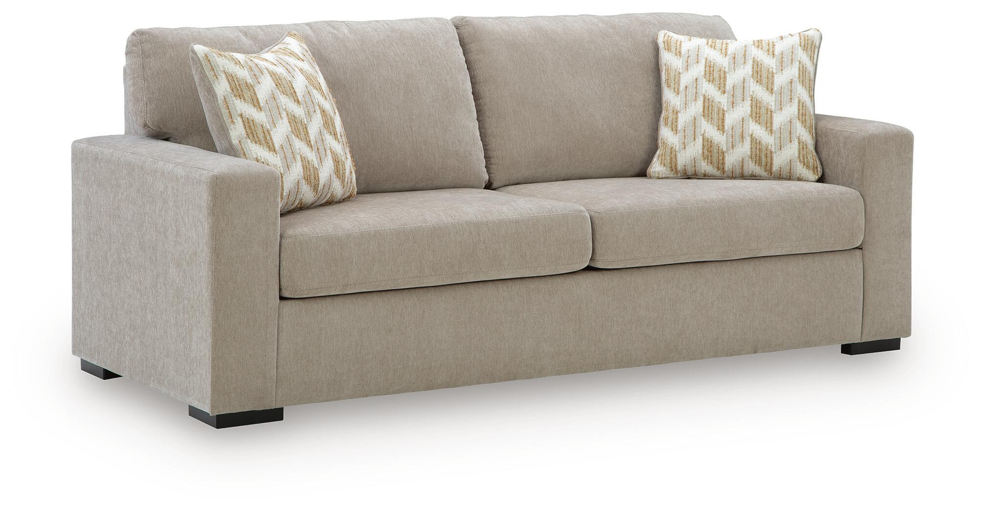 Light gray sofa sleeper with two patterned throw pillows and dark base feet