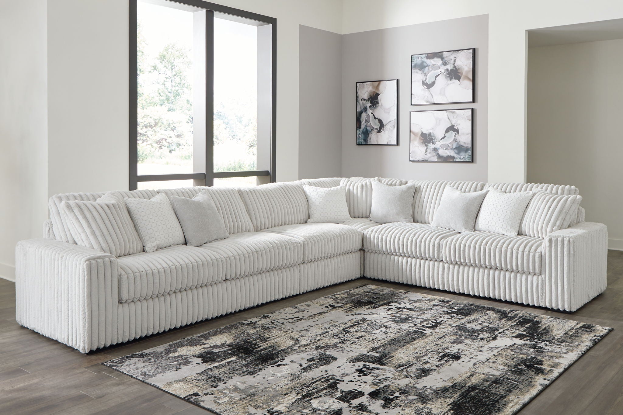 Gray sectional sofa with chaise, ribbed upholstery and plush tufted back pillows