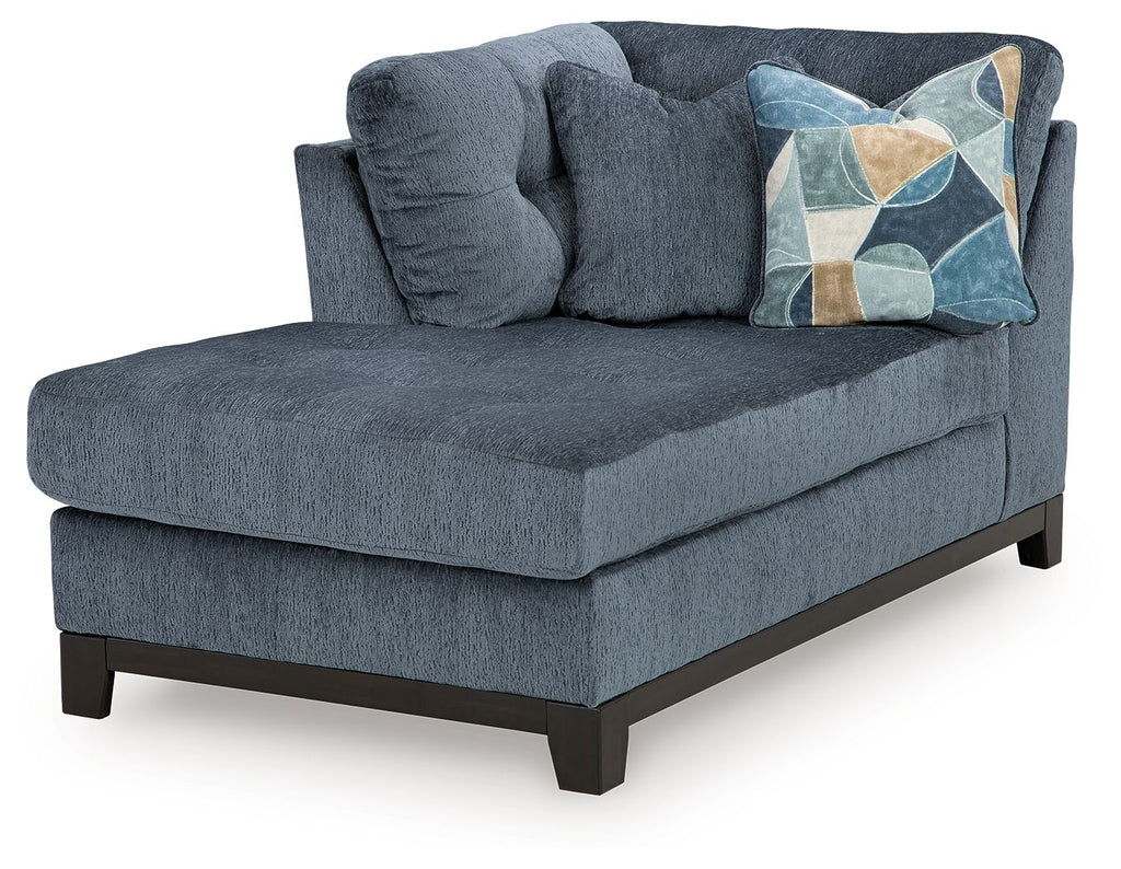 Navy corner chaise sofa with tufted back, geometric throw pillow, dark wood legs