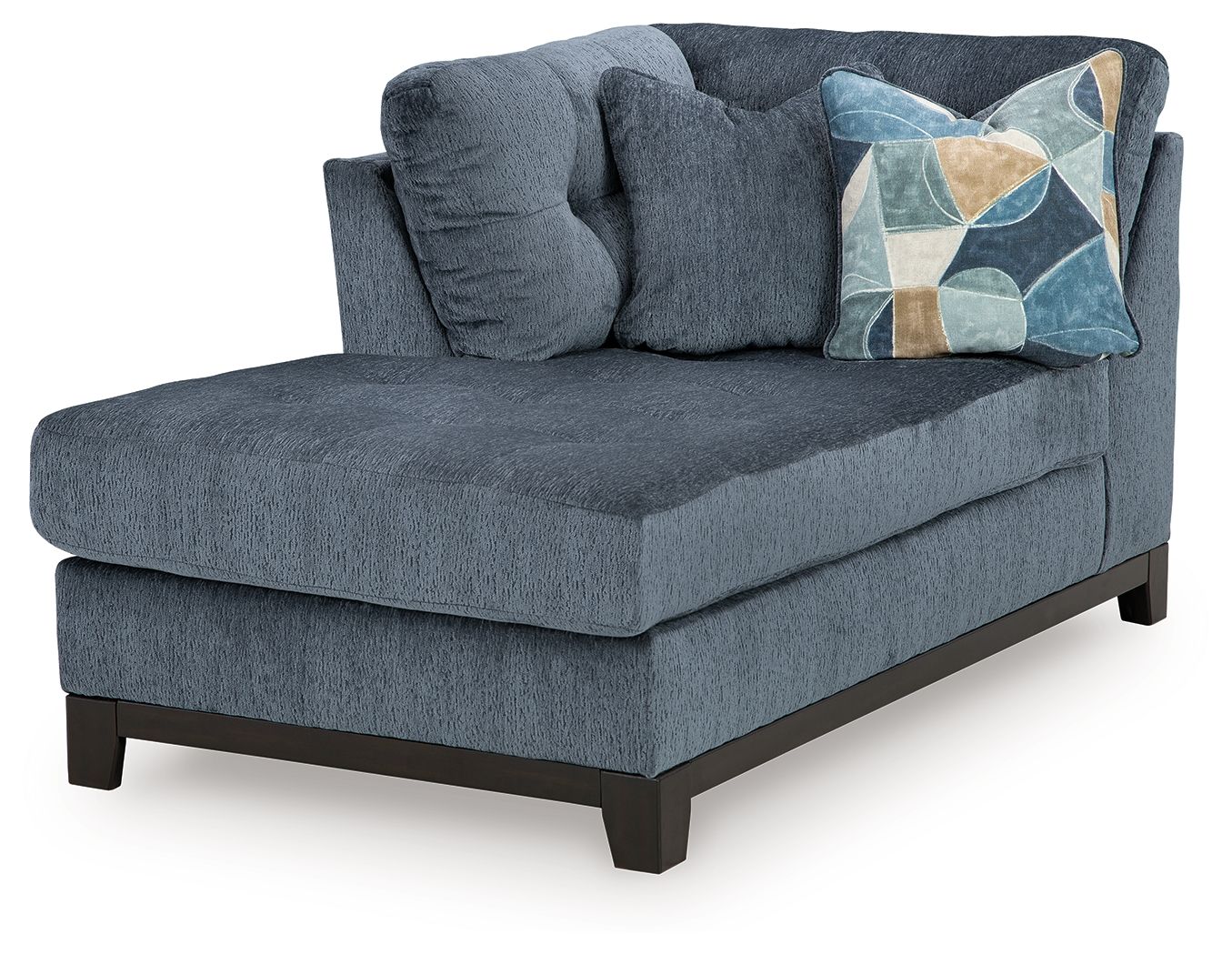 Navy corner chaise sofa with tufted back, geometric throw pillow, dark wood legs