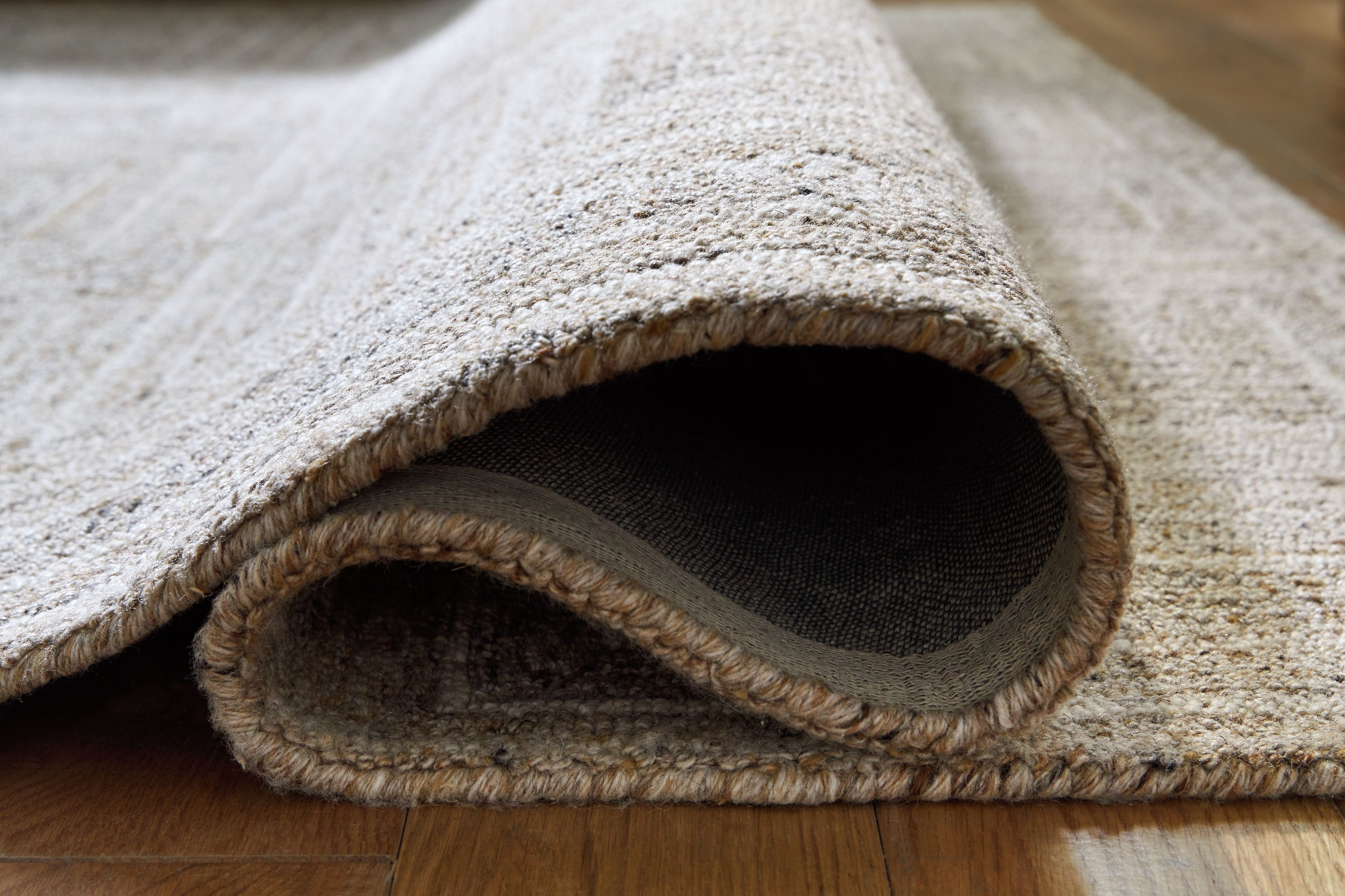 Gray area rug with bound edge and short textured pile