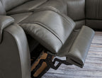 Power recliner with dark gray padded arm and seat, showing reclining linkage under the sofa