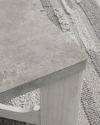 Occasional table with textured gray top and whitewash open side supports