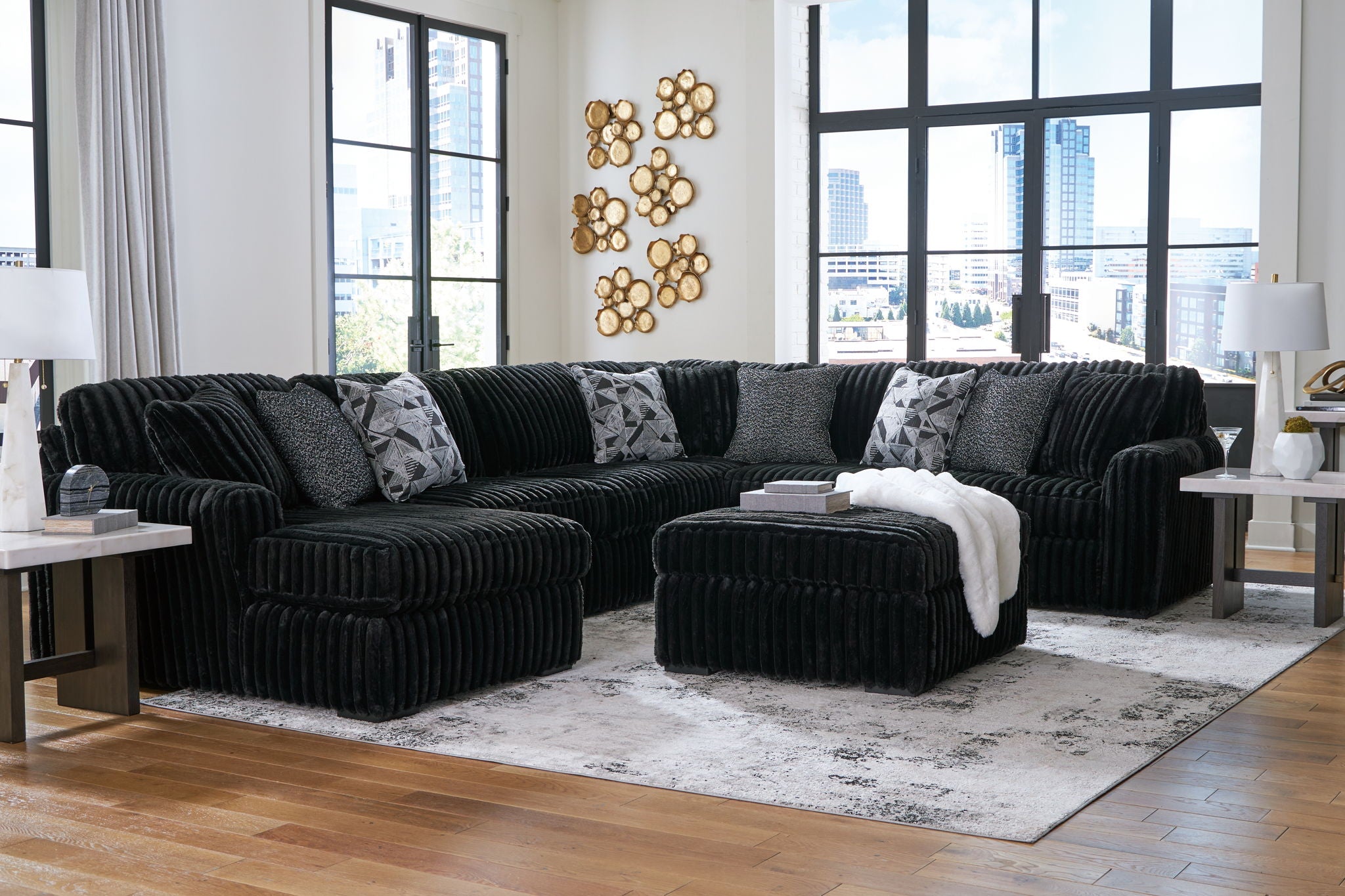 Black sectional sofa set with multiple ottomans and decorative patterned pillows
