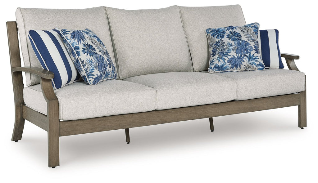 Light gray sofa with two blue patterned throw pillows and striped cushions, dark wood frame
