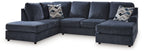 Blue sectional sofa with ottoman, low arms and patterned throw pillows