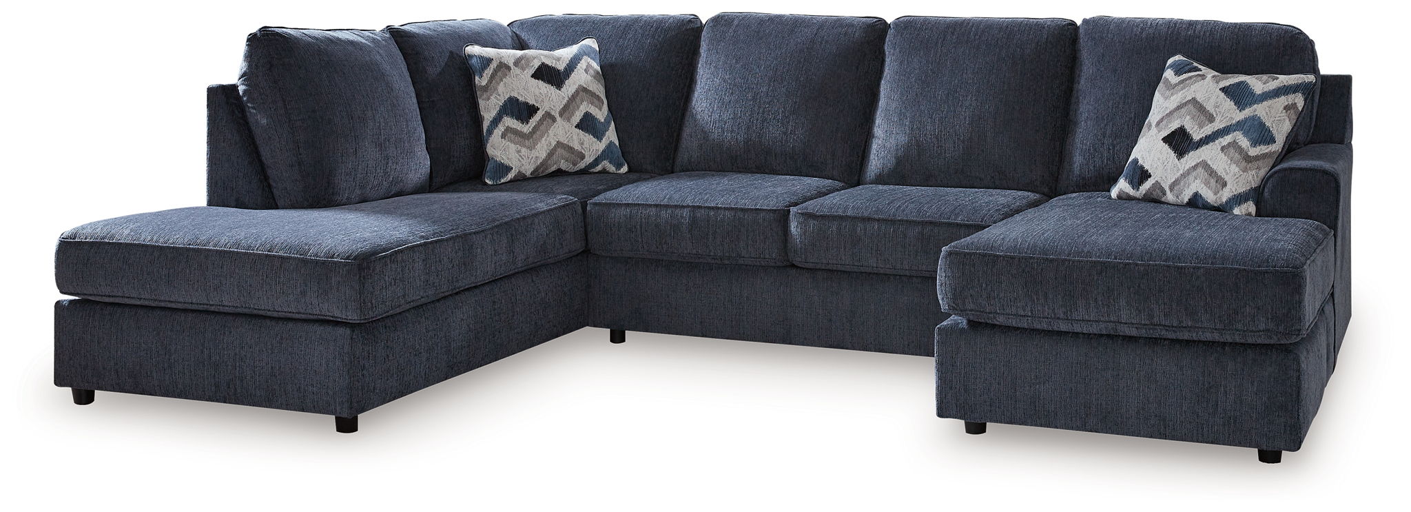 Blue sectional sofa with ottoman, low arms and patterned throw pillows