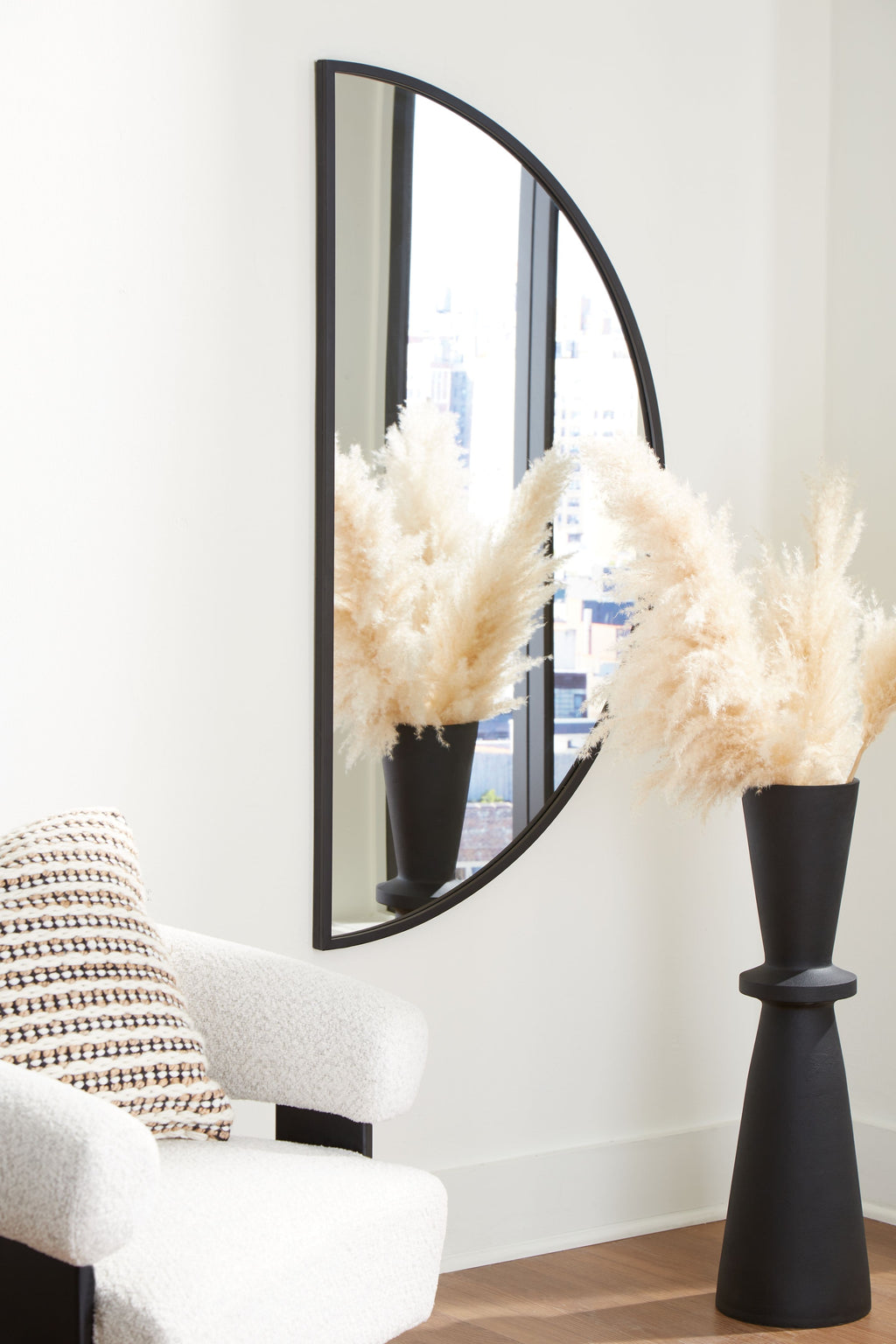 Tall arched accent mirror with black frame and reflective glass panel.