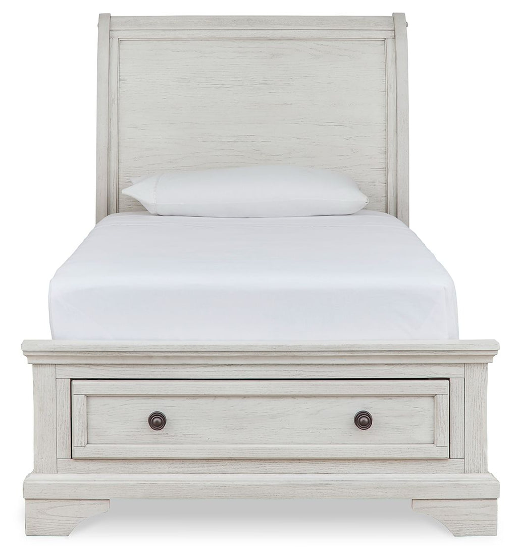 White sleigh bed with two storage drawers in the footboard and paneled headboard.